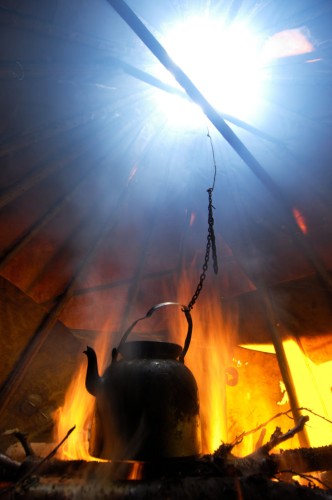 Coffee Pot boiling in a traditional Sami tent, a Goahti, or Kåta, on a Reindeer sledding safari ecotourism, at Övre Soppero, Lapland, Norrbotten, Sweden.